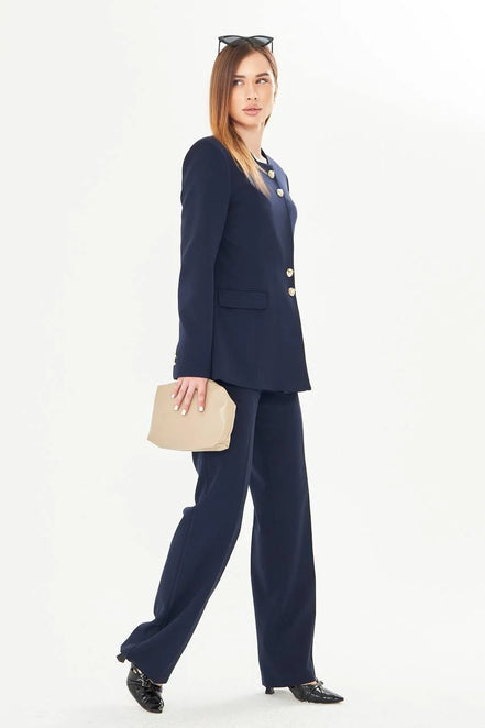 Woman wearing a navy blue suit with gold buttons