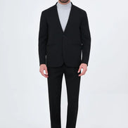 black two-piece suit with a light gray turtleneck sweater and black loafers