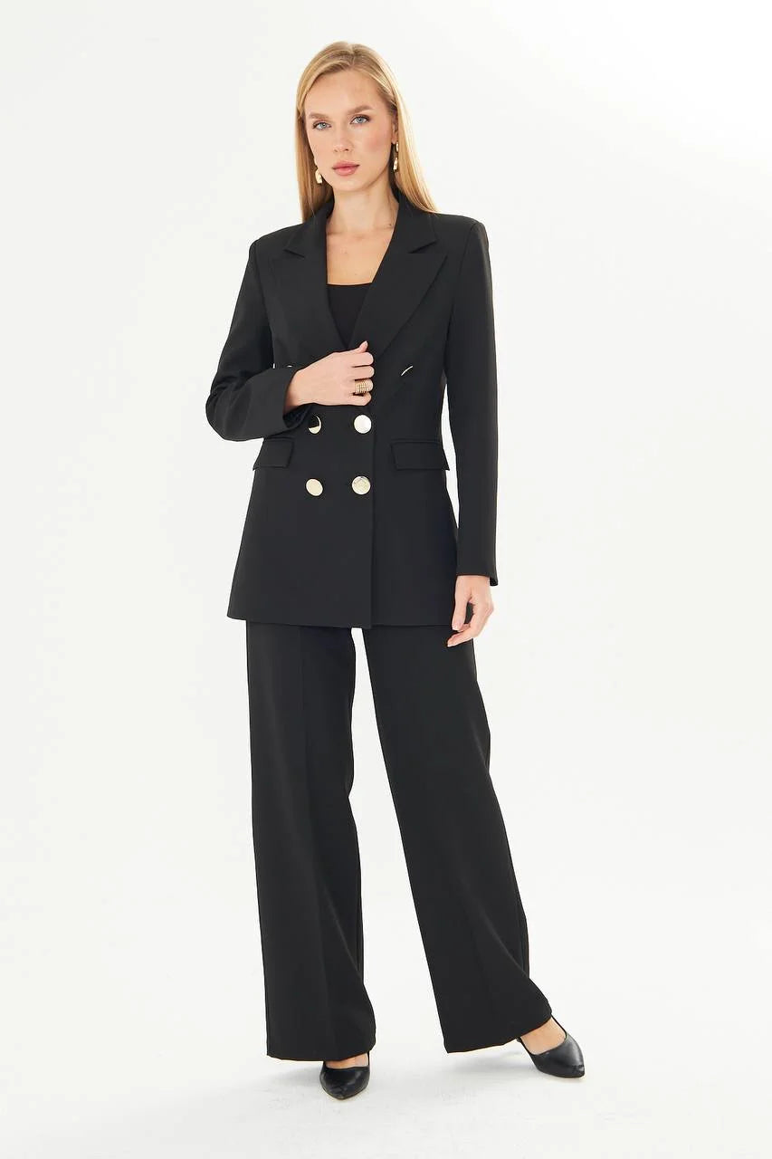 Woman wearing a black suit with gold buttons