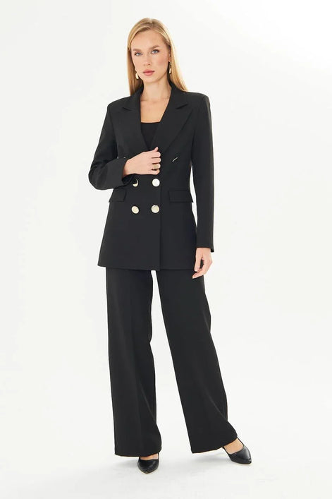 Woman wearing a black suit with gold buttons
