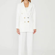 Woman wearing a white suit with gold buttons