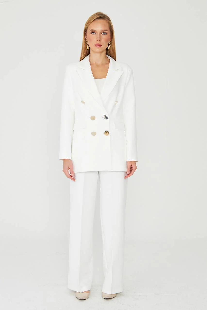 Woman wearing a white suit with gold buttons
