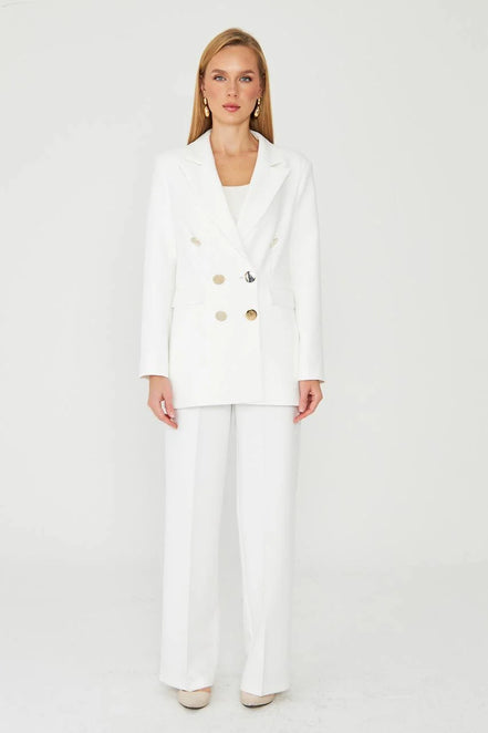 Woman wearing a white suit with gold buttons