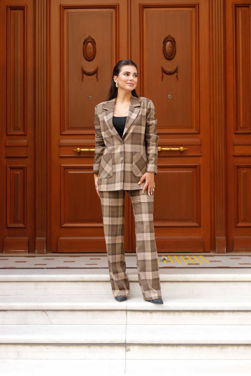 Woman in a plaid suit standing in front of a wooden door