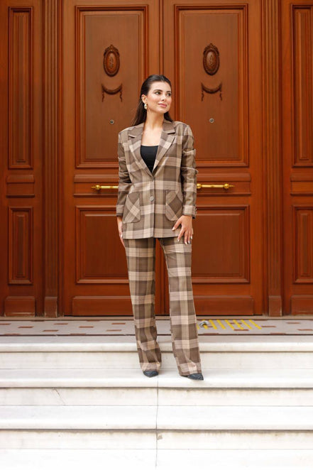 Woman in a plaid suit standing in front of a wooden door